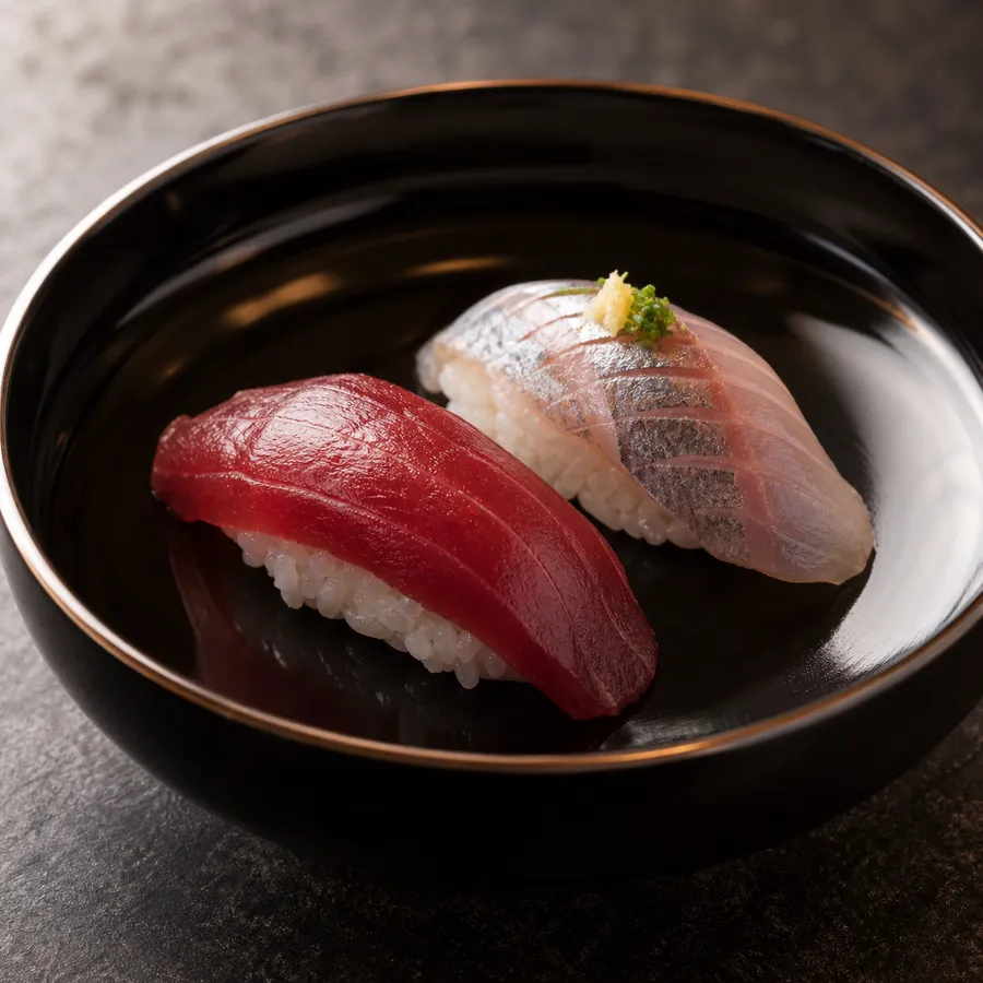 黒い器に盛られたマグロとシマアジの握り